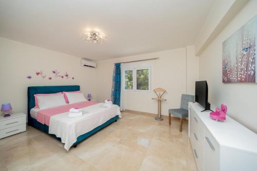 a bedroom with a bed and a flat screen tv at Melograno in Markopoulo