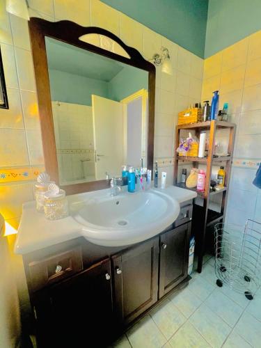 a bathroom with a sink and a large mirror at Myrto Signature Villa - Aegina in Aegina
