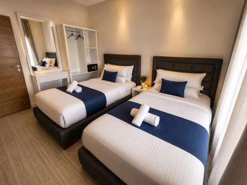 zwei Betten in einem Hotelzimmer mit Handtüchern darauf in der Unterkunft Matar Residence Hotel Suites in Al Bawsharīyah