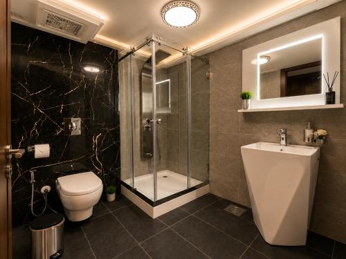 ein Badezimmer mit Toilette, Dusche und Waschbecken in der Unterkunft Matar Residence Hotel Suites in Al Bawsharīyah
