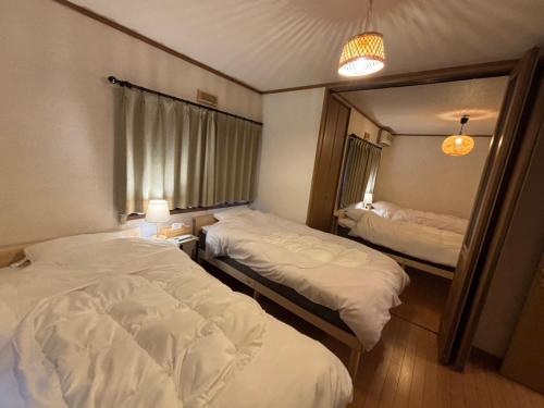 a hotel room with two beds and a mirror at ENZAN STAYS Yamanashi in Enzan