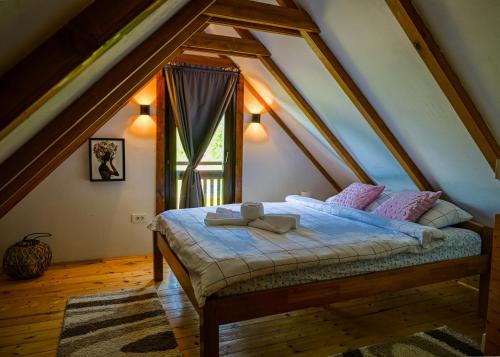a bedroom with a bed in a attic with a window at Kuća za odmor Josipa in Klanjec