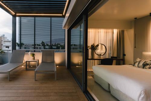 a bedroom with a large bed and a balcony at Brasil Suites Boutique Hotel in Athens