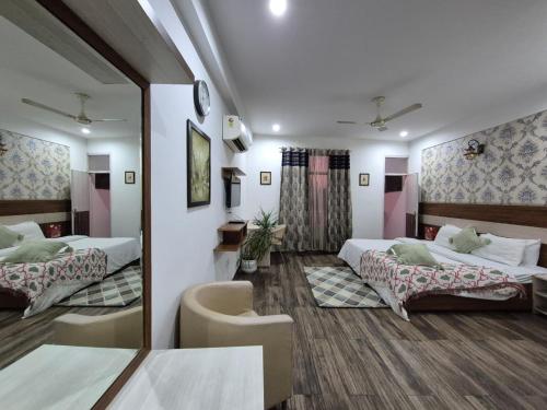 a hotel room with two beds and a mirror at Arch Place in Gurgaon