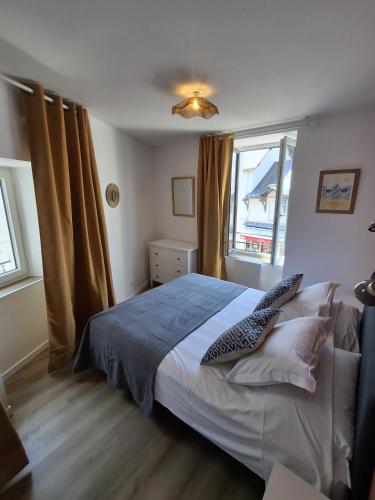 a bedroom with a bed and two windows at Appart 'Hôtel Le Mondes in Le Pouliguen