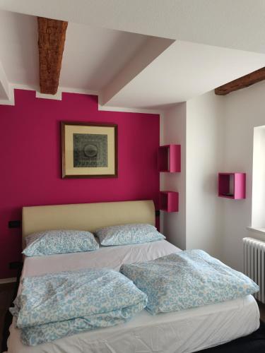 a bedroom with a purple wall and a bed at Nancy House in Longarone