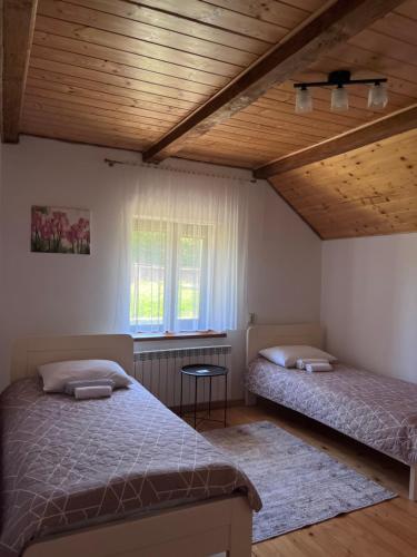 a bedroom with two beds and a wooden ceiling at Hillside in Slavske