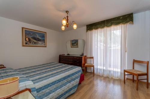 a bedroom with a bed and a dresser and a mirror at Casa Anna in Predazzo