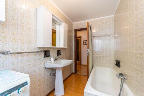 a bathroom with a sink and a toilet and a tub at Casa Anna in Predazzo