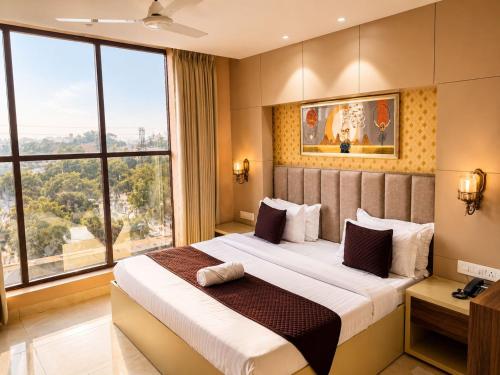 ein Schlafzimmer mit einem großen Bett und einem großen Fenster in der Unterkunft Hotel Supreme Regency in Ludhiana