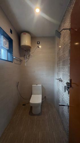 a bathroom with a toilet and a shower at Elysian Villa by Hostel Jerusalem in Kodaikānāl