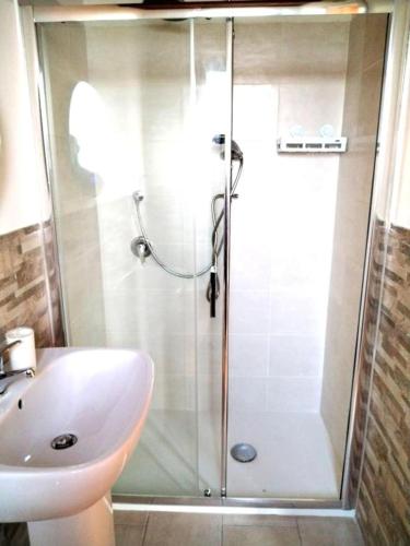 a shower with a glass door next to a sink at La Scienza Nuova in Vatolla