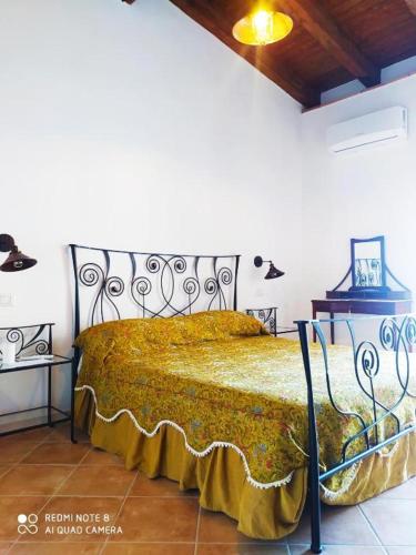 a bedroom with a bed with a gold bedspread at La Scienza Nuova in Vatolla