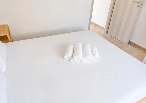 two towels sitting on top of a white bed at Ionian Studio in Lixouri