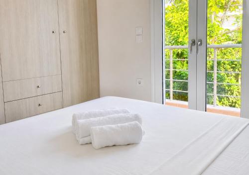 a white bedroom with two towels on a bed at Ionian Studio in Lixouri