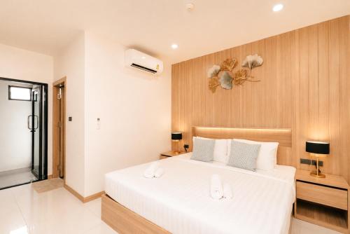 a bedroom with a large white bed in a room at Love Rawai Hotel in Rawai Beach