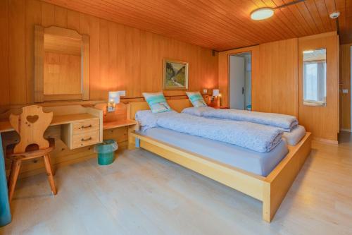 a bedroom with a bed and a desk and a table at self-check-in Hotel Regina Beatenberg in Beatenberg
