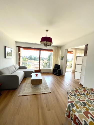 a living room with a couch and a table at Au Beau Voyage à 2 pas des Thermes in Thonon-les-Bains