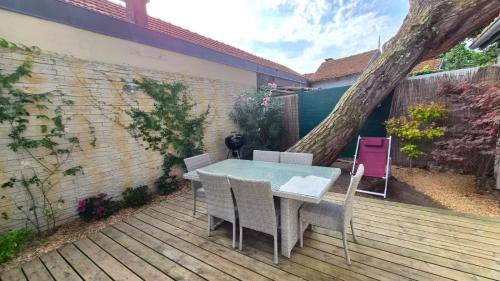 a table and chairs sitting on a wooden deck at Villa Bagatelle, climatisée, à 250m de la plage centrale, 3 chambres in Arcachon