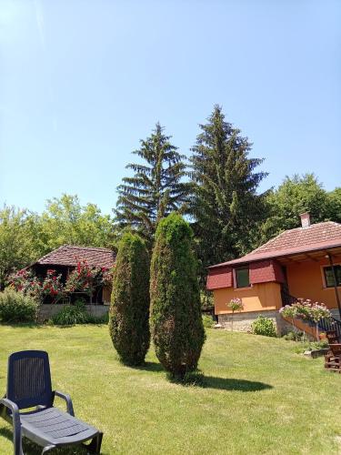 a chair in a yard next to a house with bushes at Majdanski Kutak in Gornji Milanovac