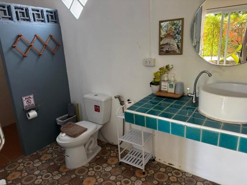a bathroom with a toilet and a sink and a mirror at SeaEsta Beach in Ban Tai