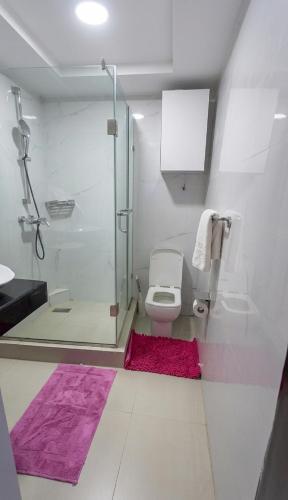 a bathroom with a toilet and a glass shower at Novatel Radisson Lekki in Lekki