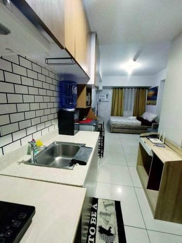 a kitchen with a sink and a living room at Horizons 101 in Cebu City