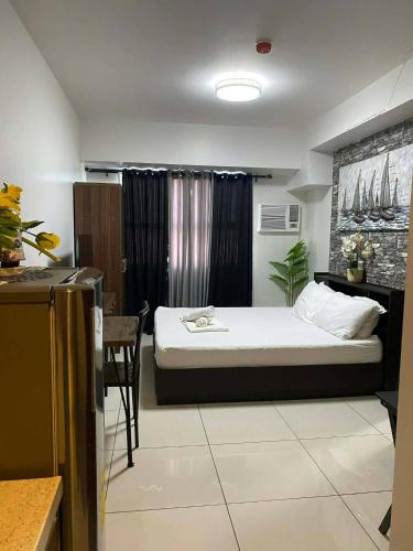 a small bedroom with a bed and a table at Horizons 101 in Cebu City