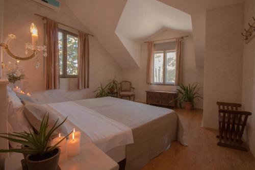a bedroom with a large white bed and windows at Villa Tamara in Bol