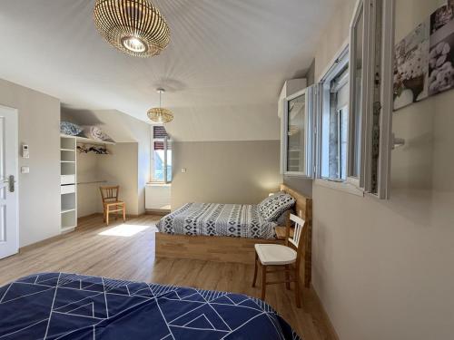 a bedroom with a bed and a chair in a room at Larrouy in Asson
