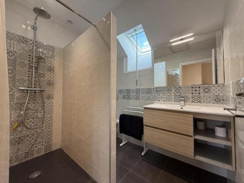 a bathroom with a shower and a sink and a mirror at Larrouy in Asson