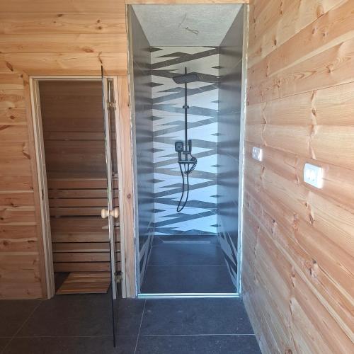 a hallway with a glass door with a chandelier at Chalet Hill Mountain Sauna in Žabljak