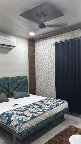 a bedroom with a bed and a ceiling fan at Hotel Dhamija Divine inn Sirsa in Sirsa
