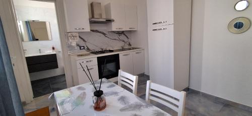 a kitchen with a table and chairs in a room at ALG Apartments in Porto Cesareo