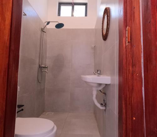 a bathroom with a toilet and a sink at Cappuccinovilla in Paje