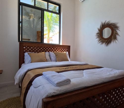a bedroom with a large bed with a large window at Cappuccinovilla in Paje
