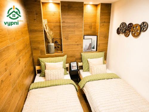 two beds in a room with wooden walls at Chalupa Oslany in Oslany