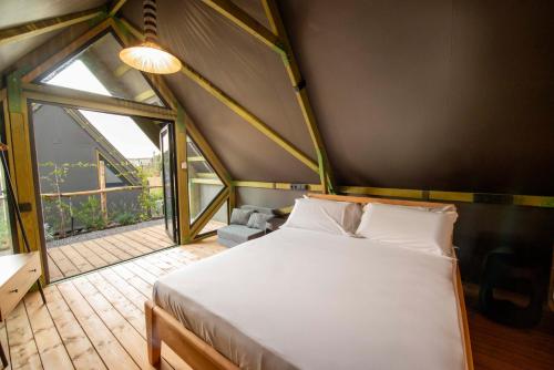 a bedroom with a bed and a large window at Maison Di Fiore Park in Ercolano