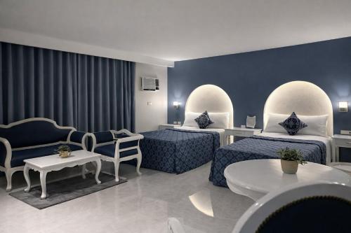 a hotel room with two beds and a couch at SM Travelodge in Batangas City
