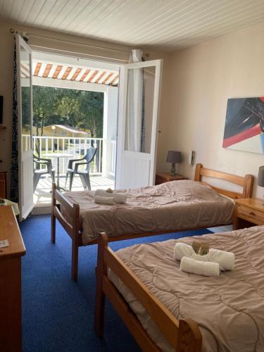 two beds in a room with a balcony at Les Chênes Verts in Saint-Savinien