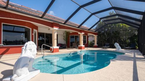 a pool with a bear statue next to a house at Villa Princess in Cape Coral