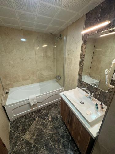 a bathroom with a tub and a sink and a shower at Almero Termal Spa Otel in Termal