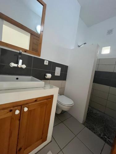 a bathroom with a toilet and a sink and a mirror at Cap-Azul in Porto Novo