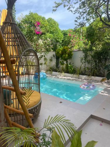 a swinging chair next to a swimming pool at Palms hotel and Spa in Fulhadhoo