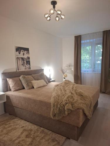 a bedroom with a large bed with a brown blanket at PT Residence in Zalaegerszeg