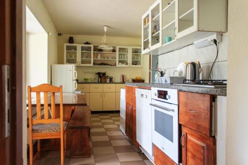 a kitchen with white appliances and a table and a chair at Ezernieki in Valka