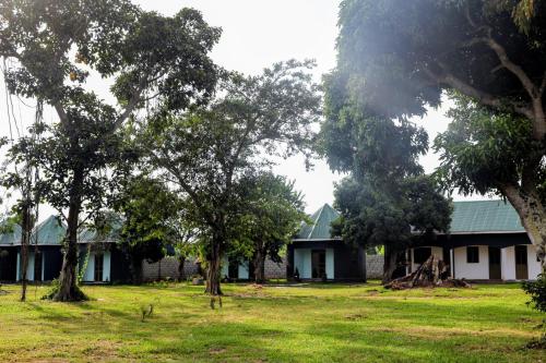 a group of houses with trees in the foreground at Dream Land Resort Beach in Mpigi