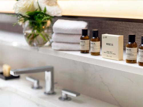 a bathroom sink with bottles of essential oils on a shelf at Fairmont Jasper Park Lodge in Jasper
