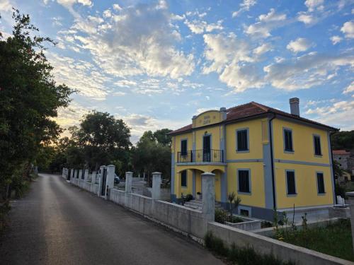 a yellow house on the side of a road at Vila Dara 1924 in Tivat
