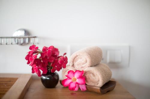 a pile of towels on a table next to a vase of flowers at Anantaya Resort & Spa Chilaw in Chilaw